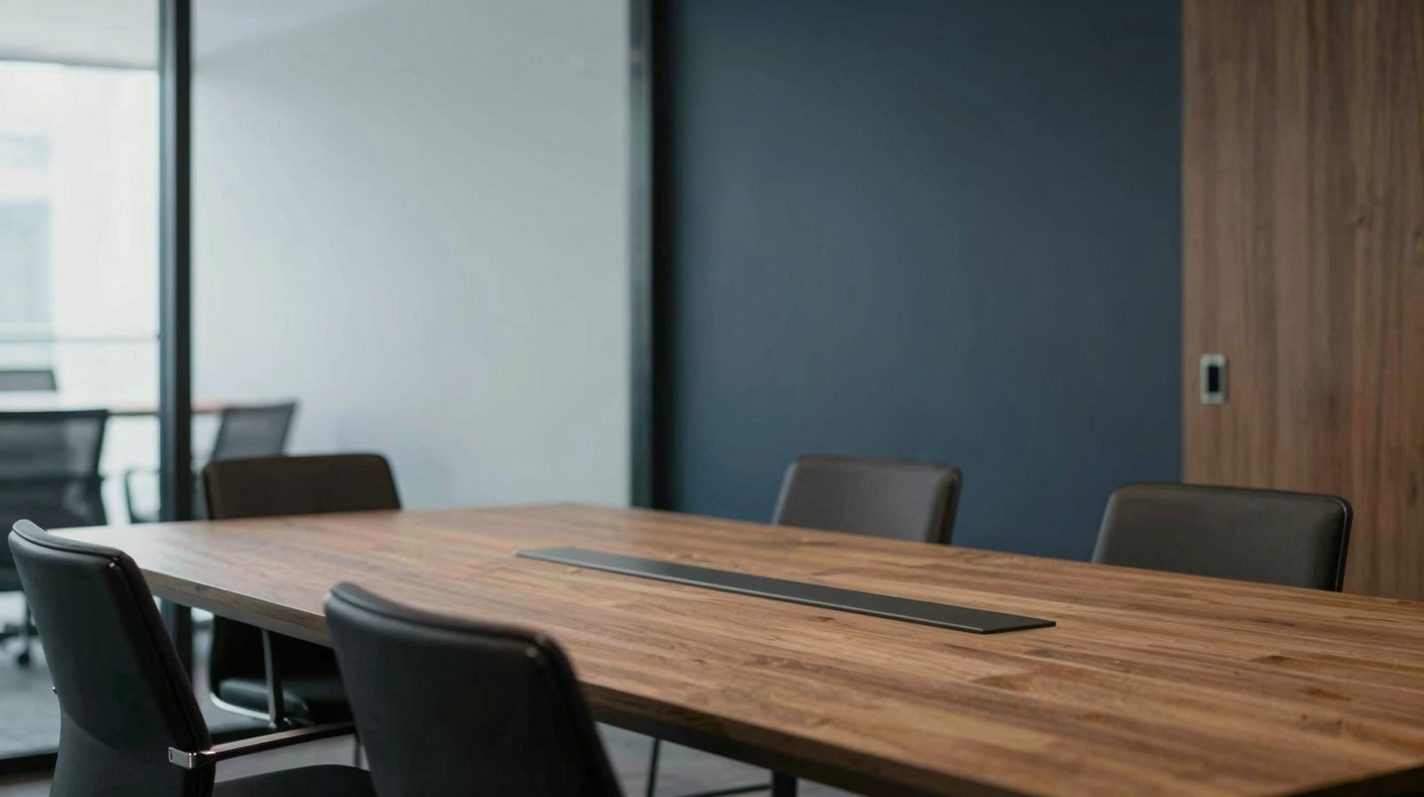 A quiet modern professional office interior with an empty meeting table